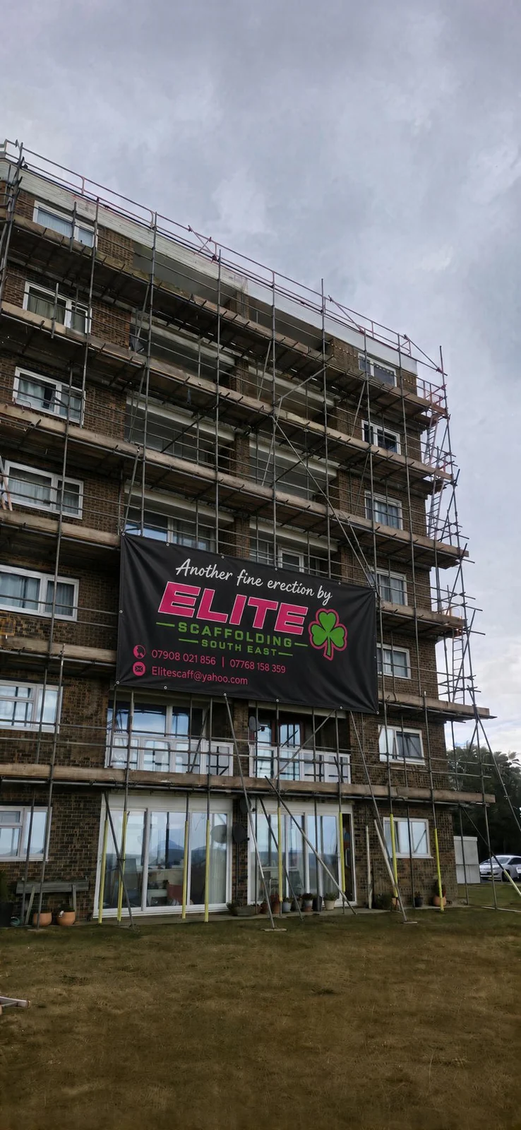 Scaffold on a brick apartment block with the Elite banner across the lift